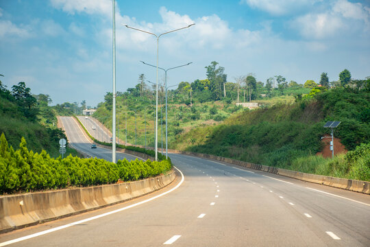 Highway linking Yaounde to Nsimalen International Airport, Cameroon. A modern and smooth road winding between green hills.