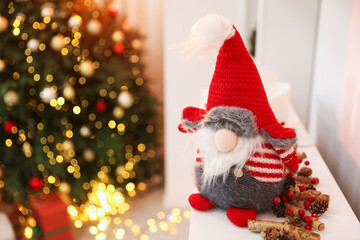 Fototapeta premium Funny Christmas gnome on dresser in decorated room, closeup