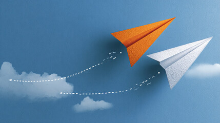 Two paper airplanes fly against blue sky