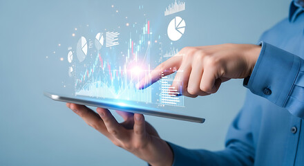 Person interacting with a futuristic tablet displaying holographic business data visualizations and financial charts.