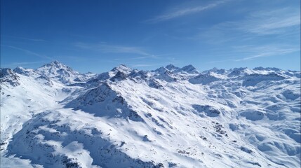 Fototapeta premium Aerial view of snow-covered Alps with a clear blue sky, showcasing breathtaking natural beauty and majestic mountain peaks.