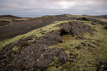 Icelandic landscape with volcanic rocks and lava fields in the foreground