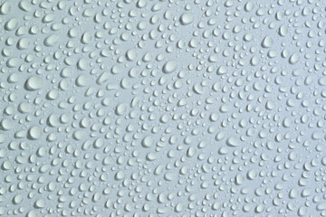 Water droplets create a delicate pattern on a smooth surface during a rainy day