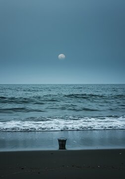 Symbolizing overwhelming scale, a tiny bucket stands near the shore attempting to capture the endless waves of the vast ocean ,wave ,endeavor ,collecting
