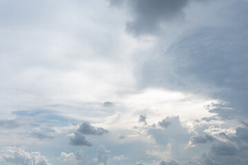 Various gray and white clouds filling the bright sky with sunlight breaking through the dense atmosphere
