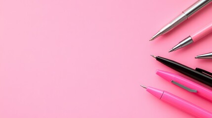 Collection of pens on pink background