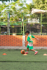 A Colombian boy in a uniform is doing a speed test during soccer practice on a field in Neiva, Huila, Colombia. Concept of childhood and healthy lifestyle