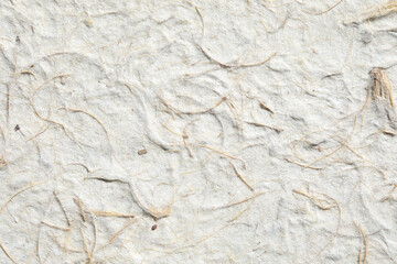 Natural mulberry paper pulp with visible dried leaves and grass