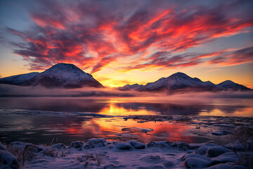 AI generated serene winter landscape with fiery red and orange sky over snowy mountains and a calm frozen lake reflecting warm light creating a peaceful majestic and quiet atmosphere