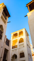 Traditional architecture in Bahrain with ornate balconies and clear blue sky.