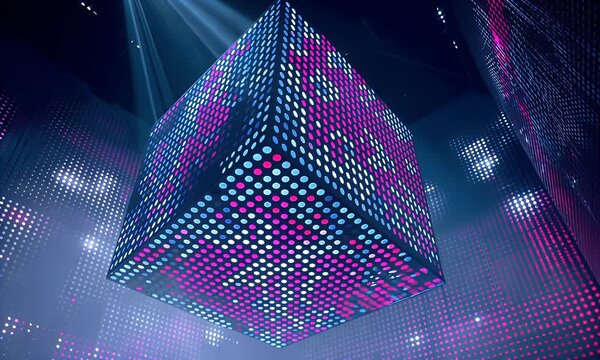 A large cube structure illuminated by numerous small colorful led lights in a dark atmospheric space with dramatic spotlights creating beams of light