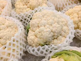 Fresh cauliflower heads in protective foam wraps