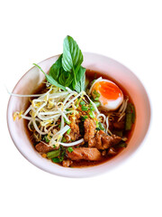 Close-up of Authentic Thai Chicken Noodle Soup with Egg, and Basil on White Background