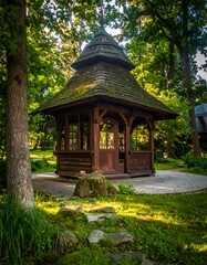 Wooden gazebo sits peacefully in a lush green park, surrounded by tall trees and patches of sunlight. A serene scene