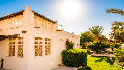 Beautiful white building with windows and green lawn under the sun.