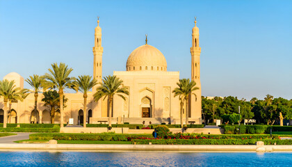 Majestic Mosque with Towering Minarets and Serene Water Reflection.