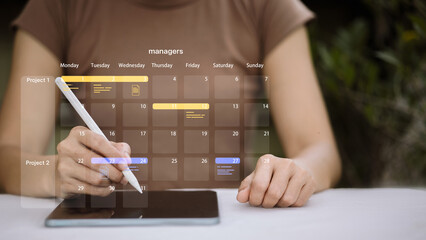 Project manager using digital calendar app on tablet for schedule planning