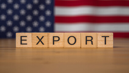 EXPORT text on wooden cubes placed on the USA flag representing American trade, foreign markets, and global business.