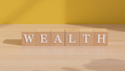 WEALTH text on wooden cubes with bright yellow backdrop illustrating finance, abundance, and money mindset.