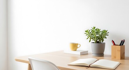 Minimalist desk setup with an open notebook, a potted plant, a yellow mug, and pens in a holder