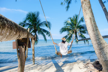 Relaxing on a beach swing under palm trees at Koh Kood Island in Thailands tropical paradise © Fokke Baarssen