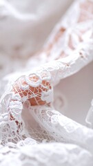 Close-up shows delicate, white lace fabric with intricate floral patterns in bright light