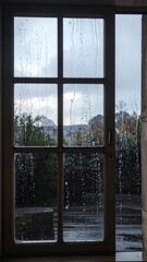 Rainy day view through a paneled window onto a landscape