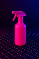 Vibrant hot-pink spray bottle on a black metallic grid surface, neon cyber-style lighting and bold contrast, ideal for edgy product ads and design visuals.
