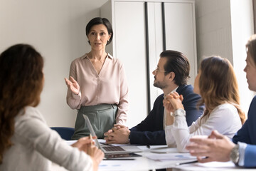 Mature female business trainer leading seminar for diverse businesspeople group