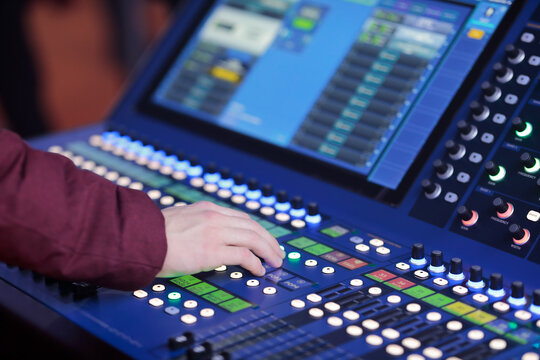 sound engineer controls live sound mixing console