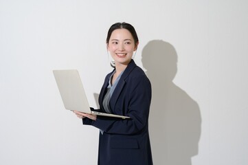 A Japanese woman holding a computer on a white background