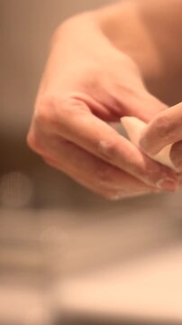 Hands preparing various Asian dumplings including jiaozi shumai har gow tang yuan and fried guo tie showing dough wrapping meat fillings in an authentic culinary process 