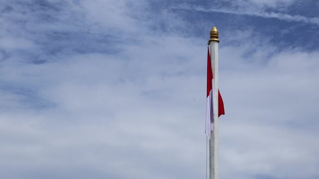 The Indonesian national flag, red and white with sky background