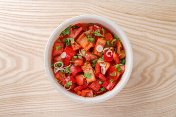 Top view of fresh red vegetable bowl on wooden table
