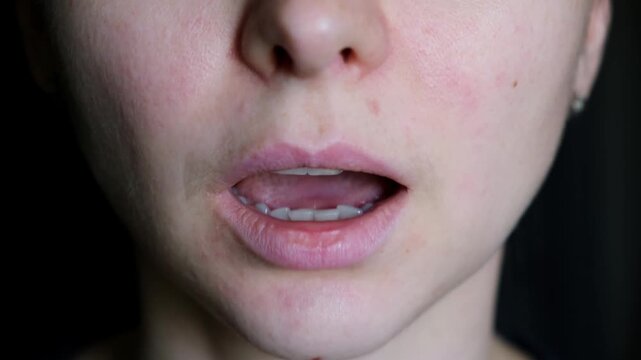 Articulatory gymnastics of the speech apparatus. Making clicking movements with the tongue and palate in the mouth close-up. The female face. Speech therapy for adults. Sounds and voice practice. 4K.