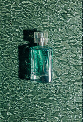 Glass perfume bottle green background top