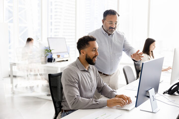 Senior Indian coach giving advice to young African American professional