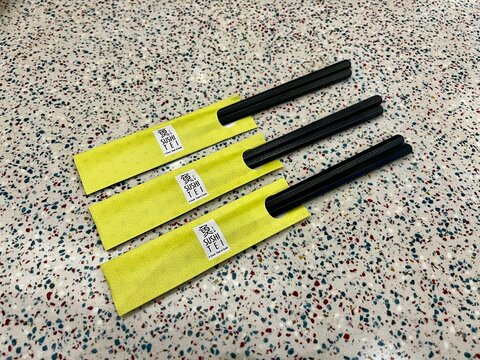 Three pairs of chopsticks with Sushi Tei label on terrazzo background on September 27, 2025 in Yogyakarta, Indonesia