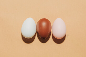 Three eggs brown white beige background