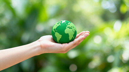 Hand holding green earth globe