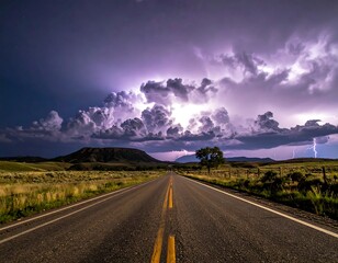 Long highway stretching to storm clouds during a lightning show