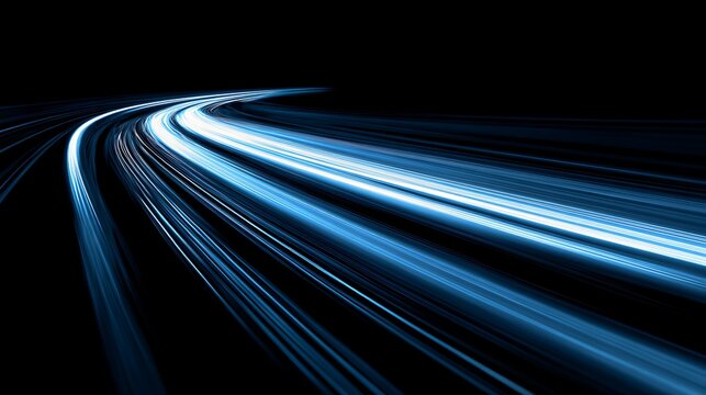Abstract streaks of bright blue light blur across a dark background creating a sense of speed and motion on a highway