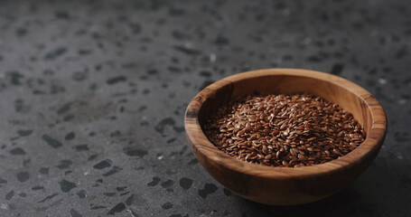 flaxseed in olive bowl on terrazzo countertop with copy space