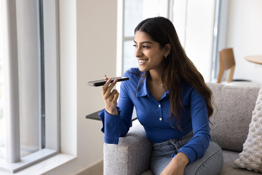 Happy young Indian woman chatting on audio call
