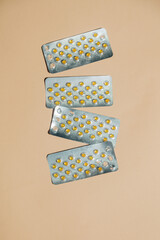 Blister packs with capsules for treating bloating are neatly arranged on a beige background