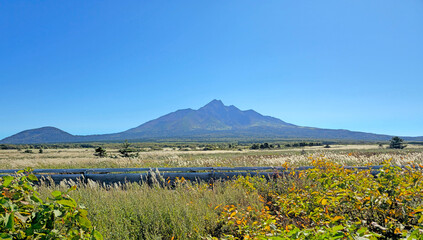The tranquil lake reflects the majestic mountain and lush forest, creating a stunning natural...