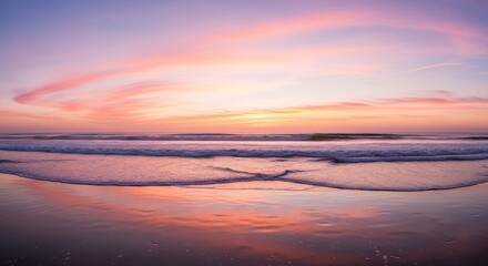 Ocean water reflects a pink and lavender sunset sky, wet sand in the foreground
