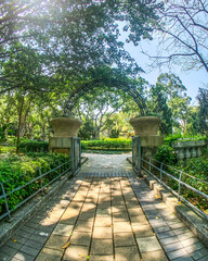 A stone pathway leads through an archway into a lush, green garden, creating a sense of peace and serenity
