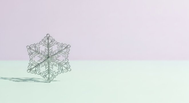 A silver snowflake on a white and mint green background. - Powered by Adobe