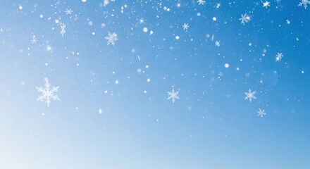 Fototapeta premium Snowflakes falling against a blue sky.